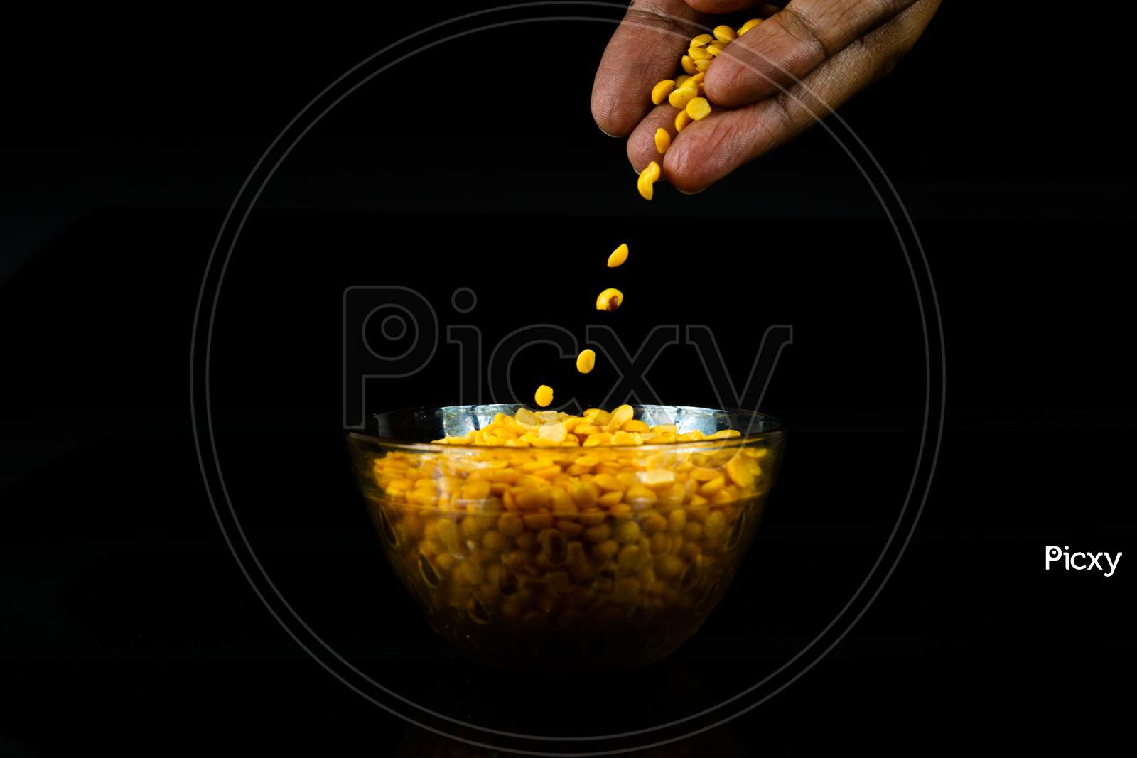 Human Hand With Split Yellow Gram In A Bowl