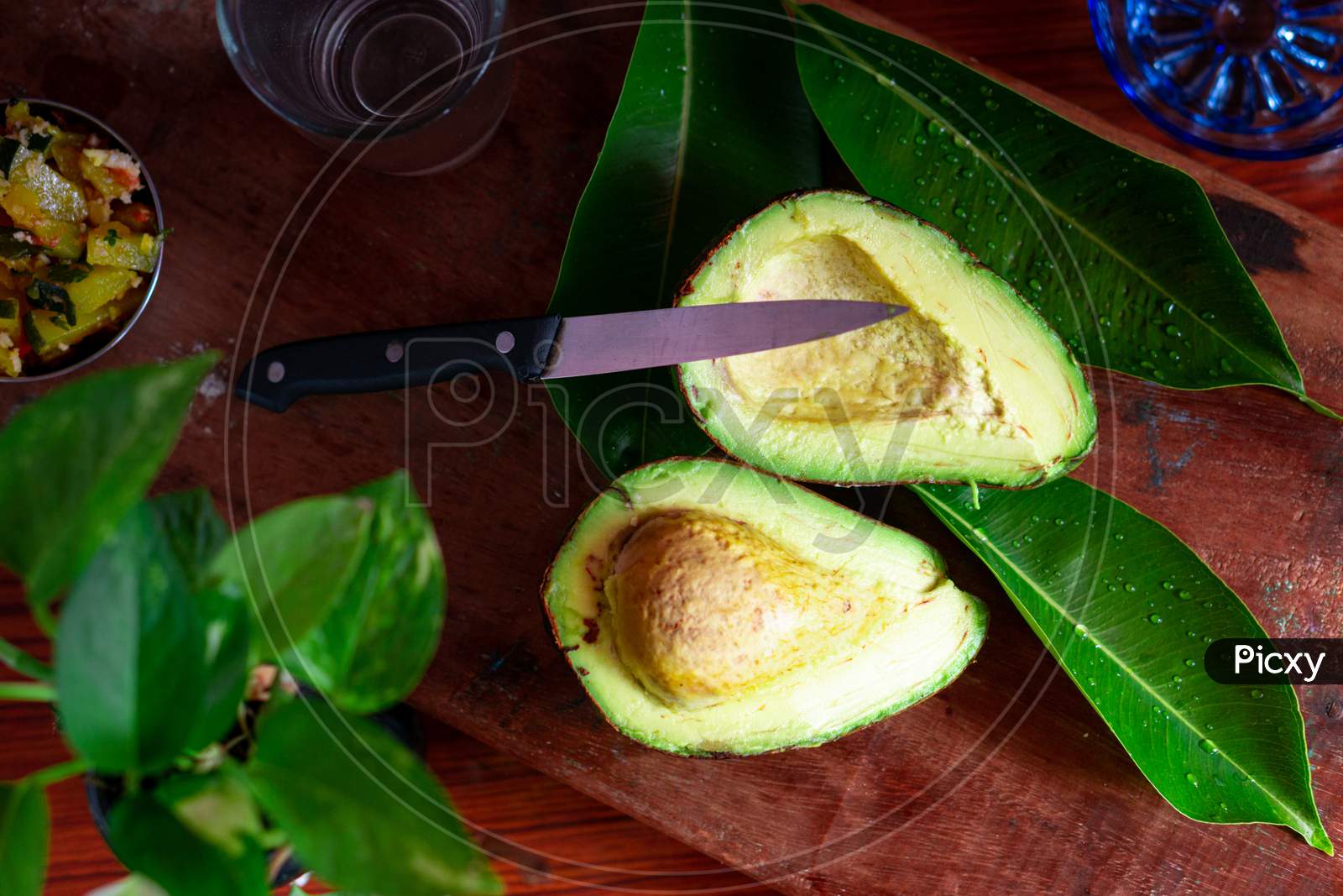 Avocado Cut Into Two Pieces With A Knife