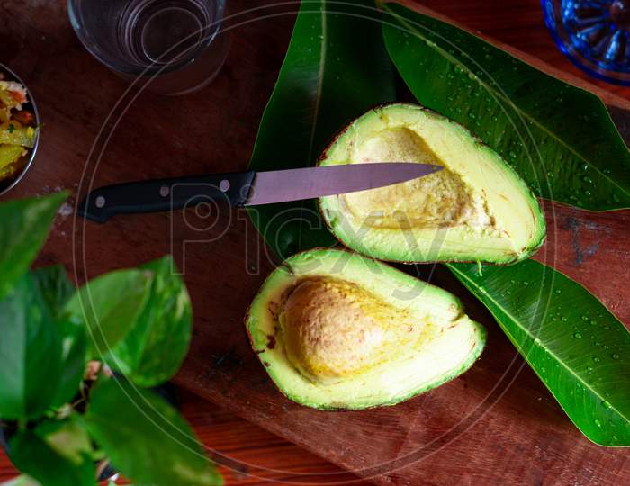 Avocado Cut Into Two Pieces With A Knife