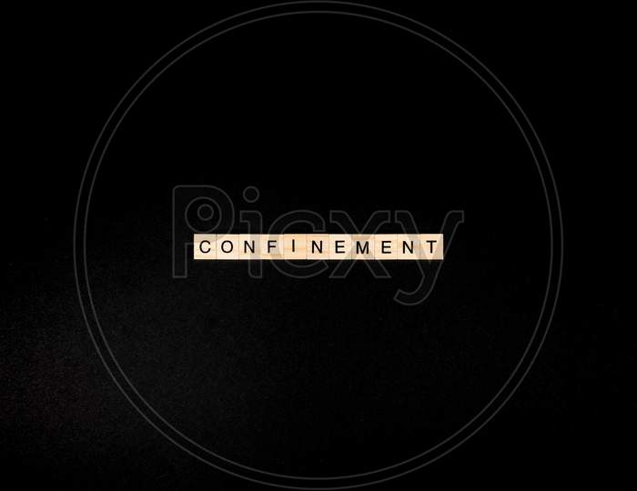 Wooden Letters On A Black Background Forming The Word “Confinement”. Second Wave During Coronavirus Pandemic Concept.