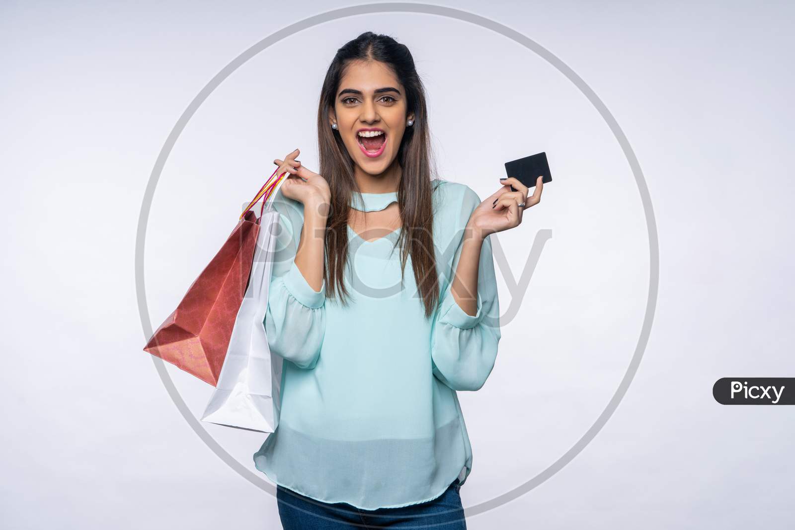 excited young Indian woman showing Card and Shopping bags