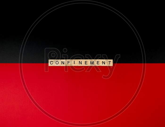 Wooden Letters On A Red And Black Background Forming The Word “Confinement”. Second Wave During Coronavirus Pandemic Concept.