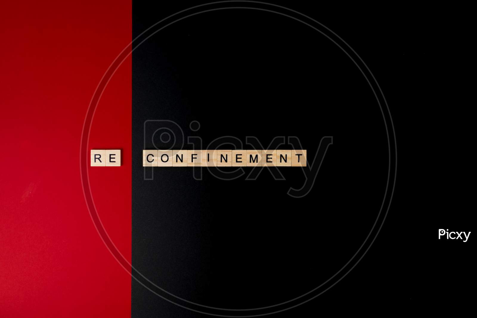 Wooden Letters On A Red And Black Background Forming The Word “Reconfinement”. Second Wave During Coronavirus Pandemic Concept.