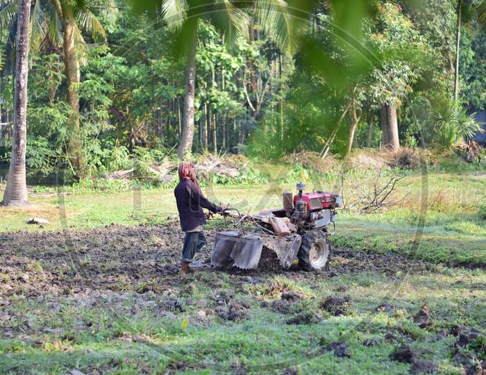 Kamalnagar, Tripura/India - November 18 2020 : A Farmer Is Plowing The Land With The Help Of A Mini Tractor For Farming.