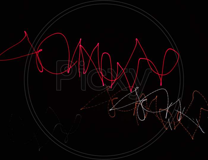 Red, orange and white colored abstract light painting photography in black background