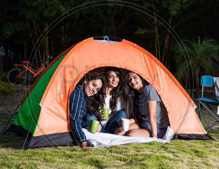 Three Indian Asian Girls Posing For Photo While Camping, Sitting In And Around Tent