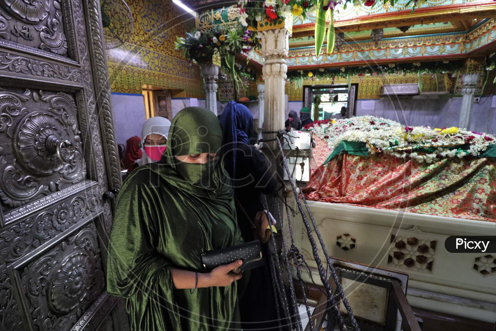 Women wearing protective masks are seen inside a shrine after religious places reopened for the public amid the spread of the coronavirus disease (COVID-19) in Mumbai, India in November, 2020.