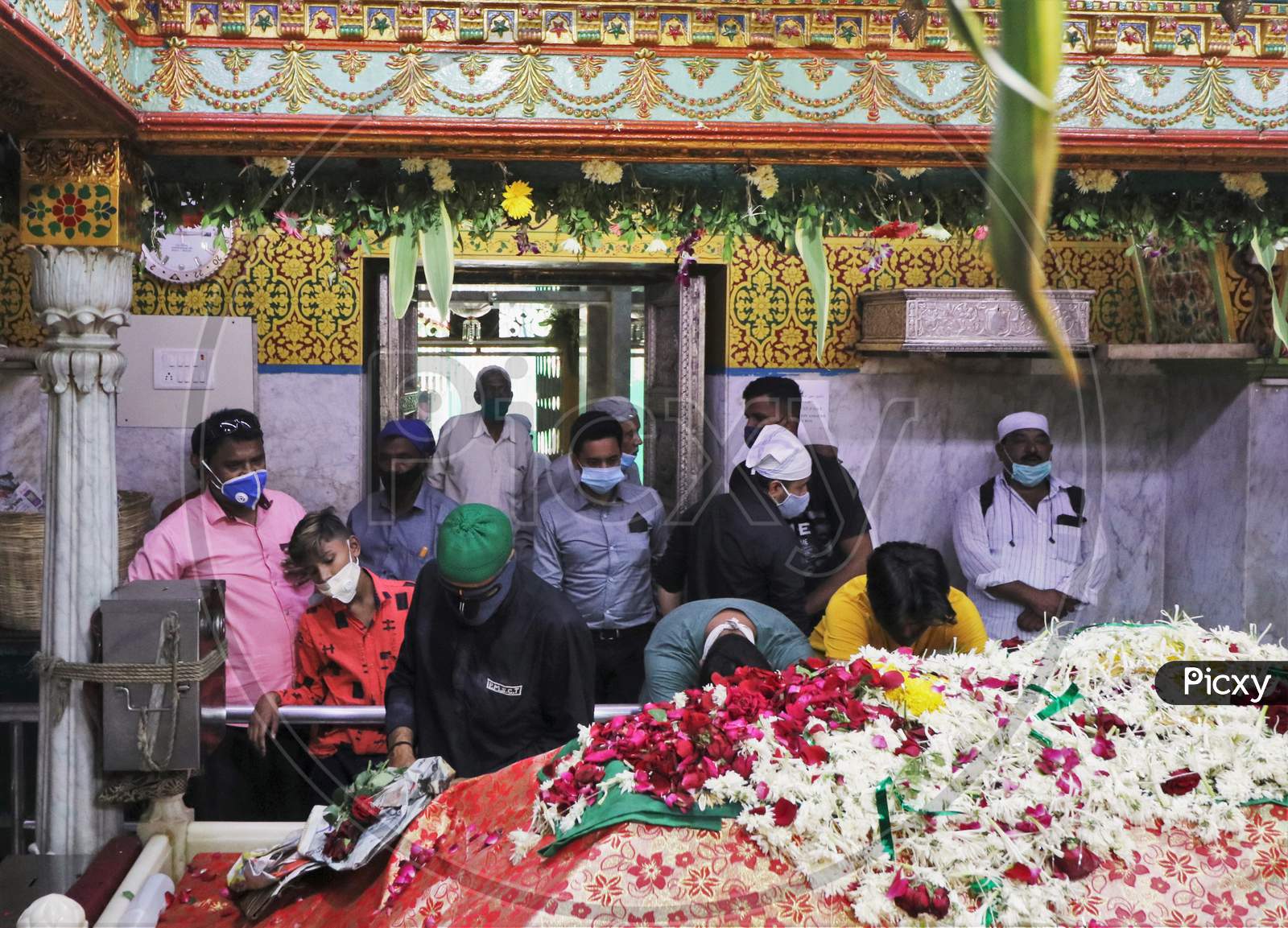 Men wearing protective masks pray inside a shrine after religious places reopened for the public amid the spread of the coronavirus disease (COVID-19) in Mumbai, India in November, 2020.
