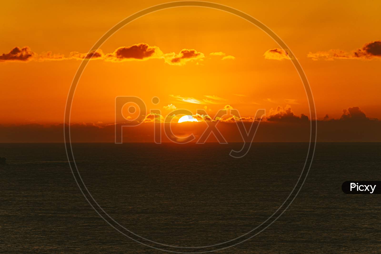 Massive Clouds Over The Horizon During A Colorful Sunset With A Giant Sun With Copy Space