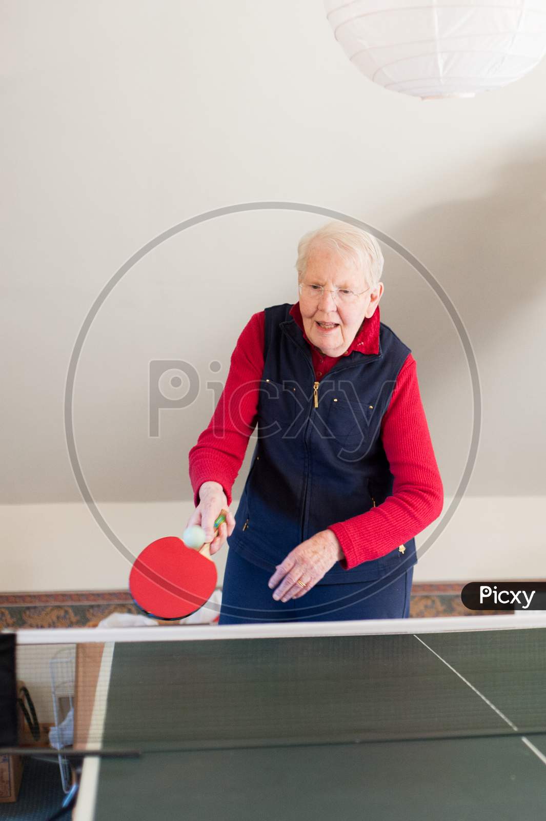 An Elderly Lady Plays Table Tennis