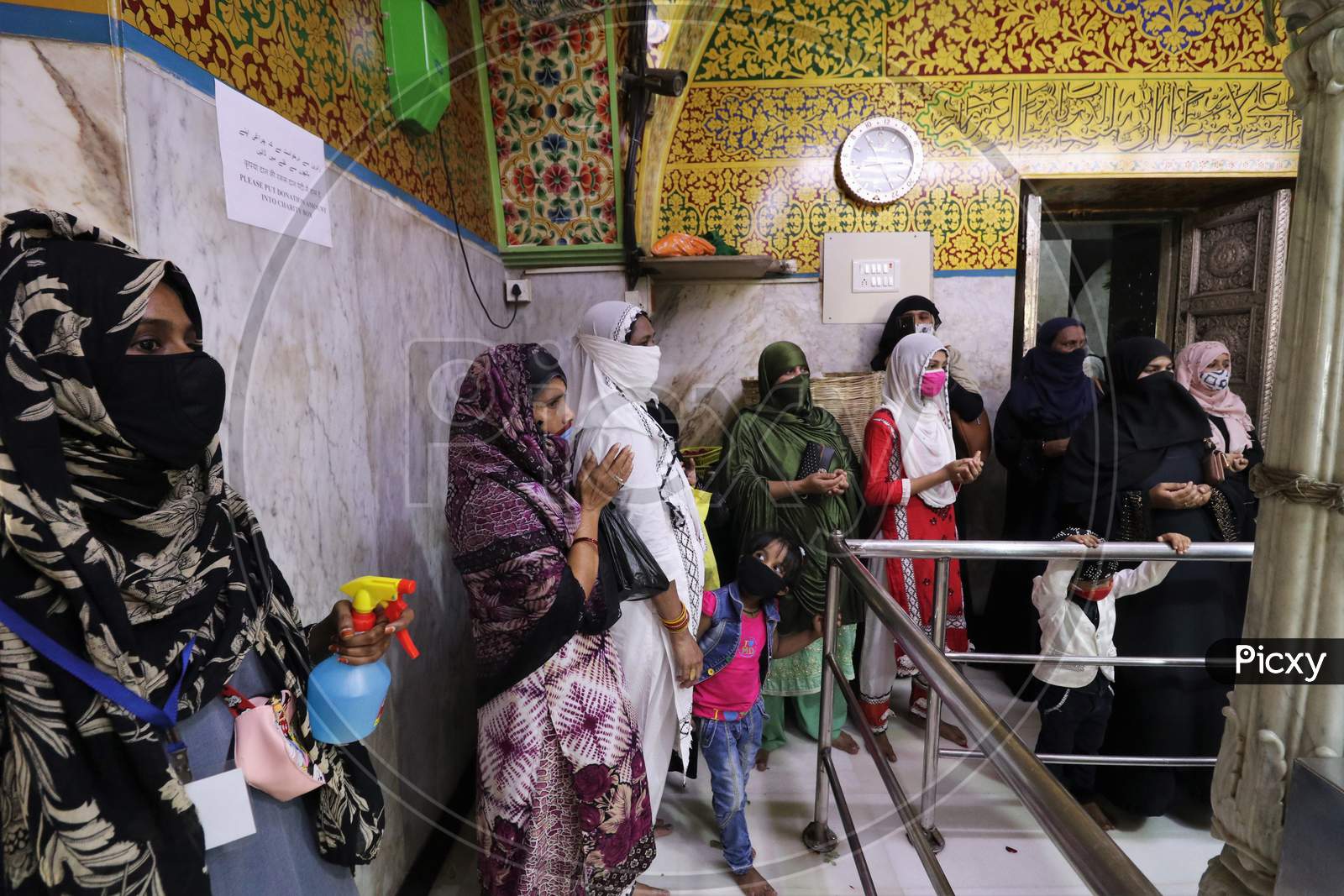 Women wearing protective masks pray inside a shrine after religious places reopened for the public amid the spread of the coronavirus disease (COVID-19) in Mumbai, India in November, 2020.