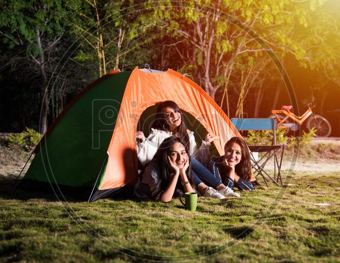 Three Indian Asian Girls Posing For Photo While Camping, Sitting In And Around Tent