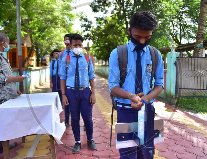 Students sanitize their hands   after schools re-opened following a gap of more then seven months due to coronavirus pandemic, in Nagaon District of Assa