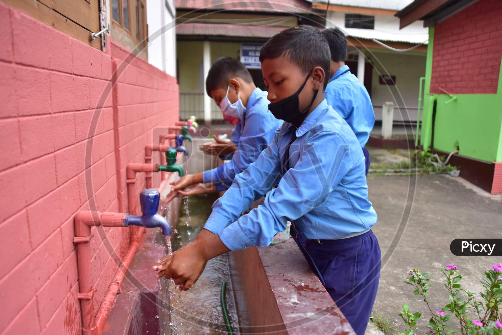 Students wash their hands  at a  School after schools re-opened following a gap of more then seven months due to coronavirus pandemic in Nagaon District of Assam on Nov 2,2020.