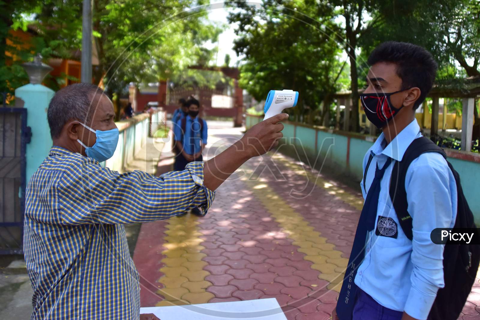 Students undergo thermal screening after schools re-opened following a gap of more then seven months due to coronavirus pandemic, in Nagaon District of Assam on Nov 2,2020.