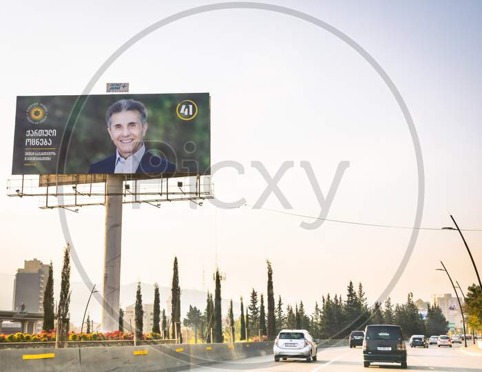 1 November, 2020. Tbilisi.Georgiaparliament Elections 2020 Agitation.Giant Billboard By The Road  With Passing Cars. Georgian Dreams Party Agitation Poster With Face Of Bidzina Ivanishvili .