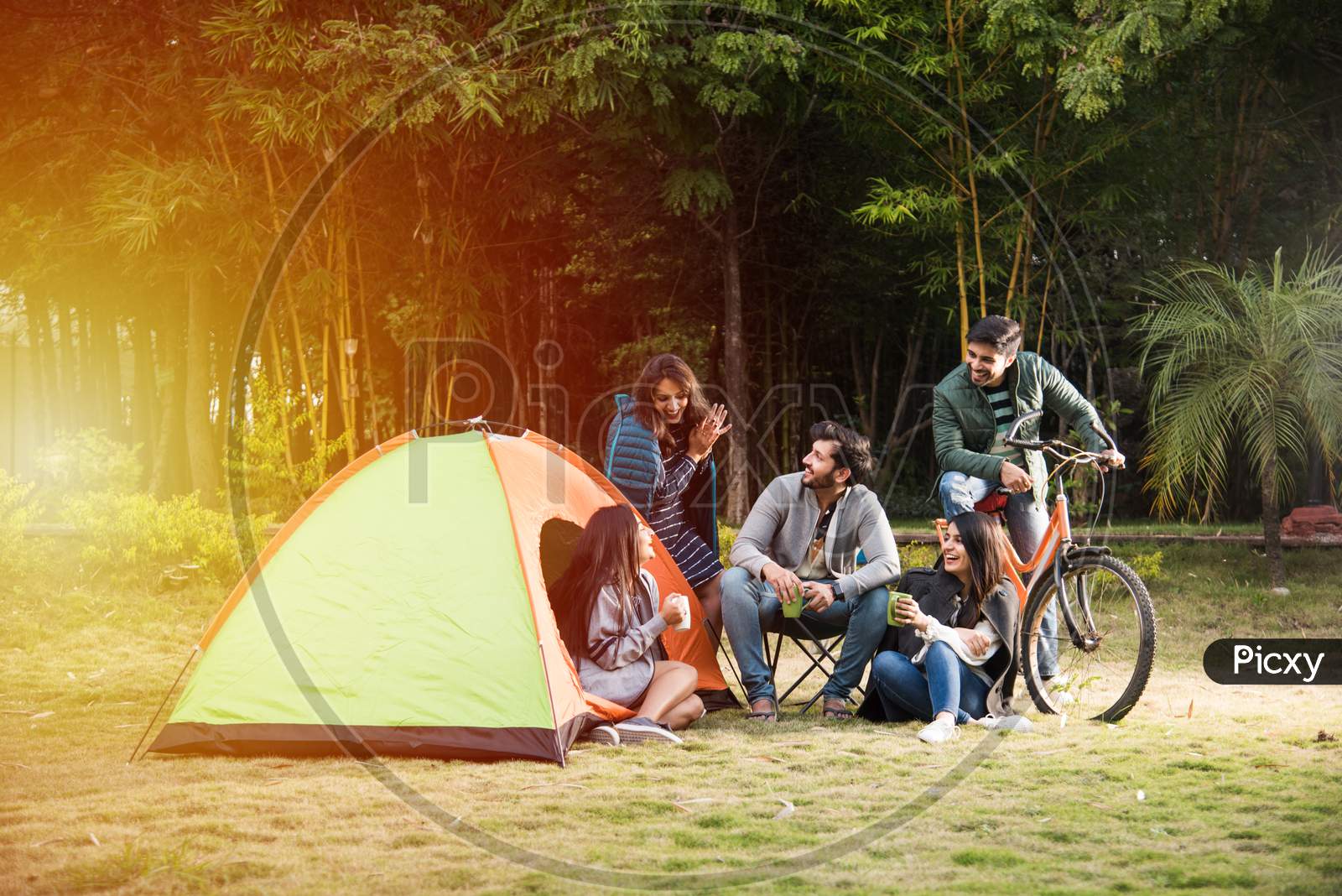 Group Of Asian Indian Young Friends Relaxing Outside Tents On Camping Holiday