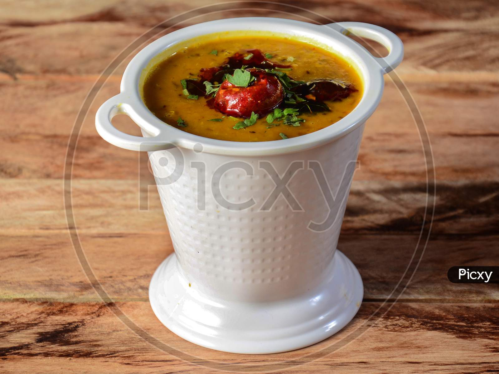 Authentic Indian Popular Food Dal Tadka Curry Or Traditional Indian Soup Lentils On Rustic Wooden Background. Selective Focus