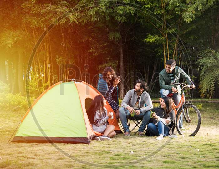 Group Of Asian Indian Young Friends Relaxing Outside Tents On Camping Holiday