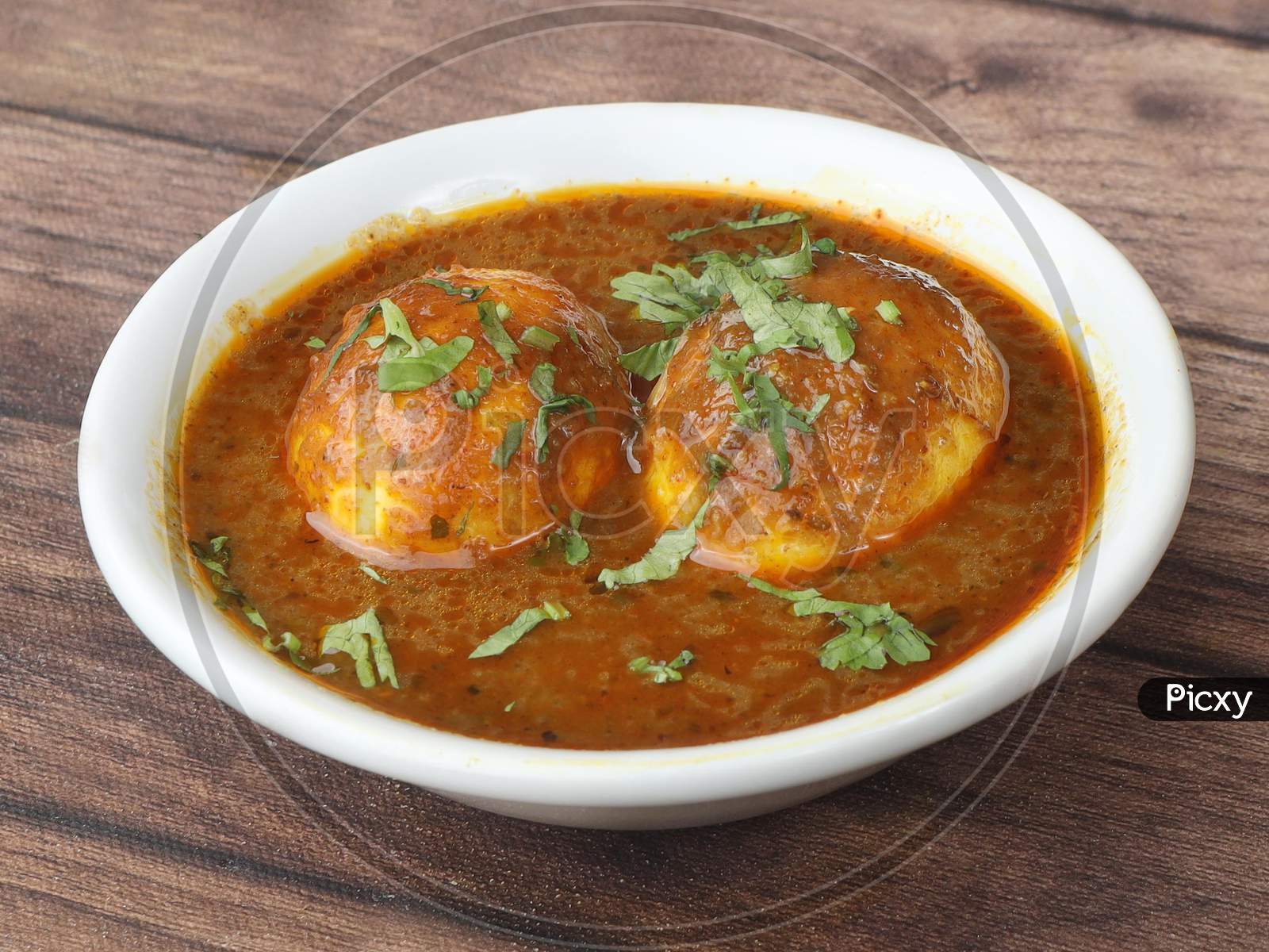 Anda Masala Or Egg Curry Is Popular Indian Spicy Food, Served In A Ceramic Bowl Over Rustic Wooden Background. Selective Focus