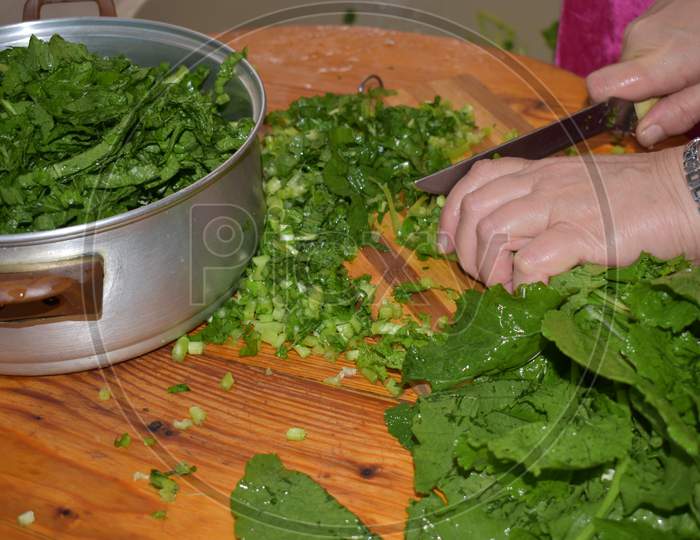 cutting green leaves for traditional food