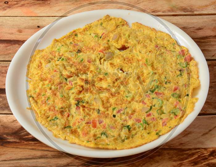 Indian Masala Egg Omelet, Made With Fresh Vegetables Tomato,Onion, Hot Chili Pepper, Parsley.. Served In Rustic Wooden Background, Selective Focus