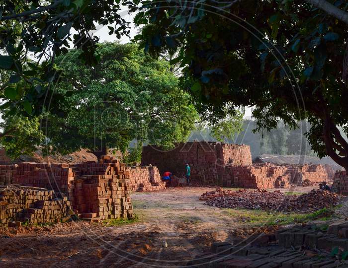 Piles of red bricks at a small brick manufacturing plant in rural Bengal.
