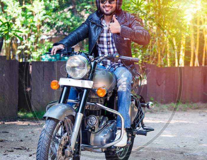 Handsome Serious Indian Asian Young Man Biker On Bike Outdoors At The Forest Field Looking Aside