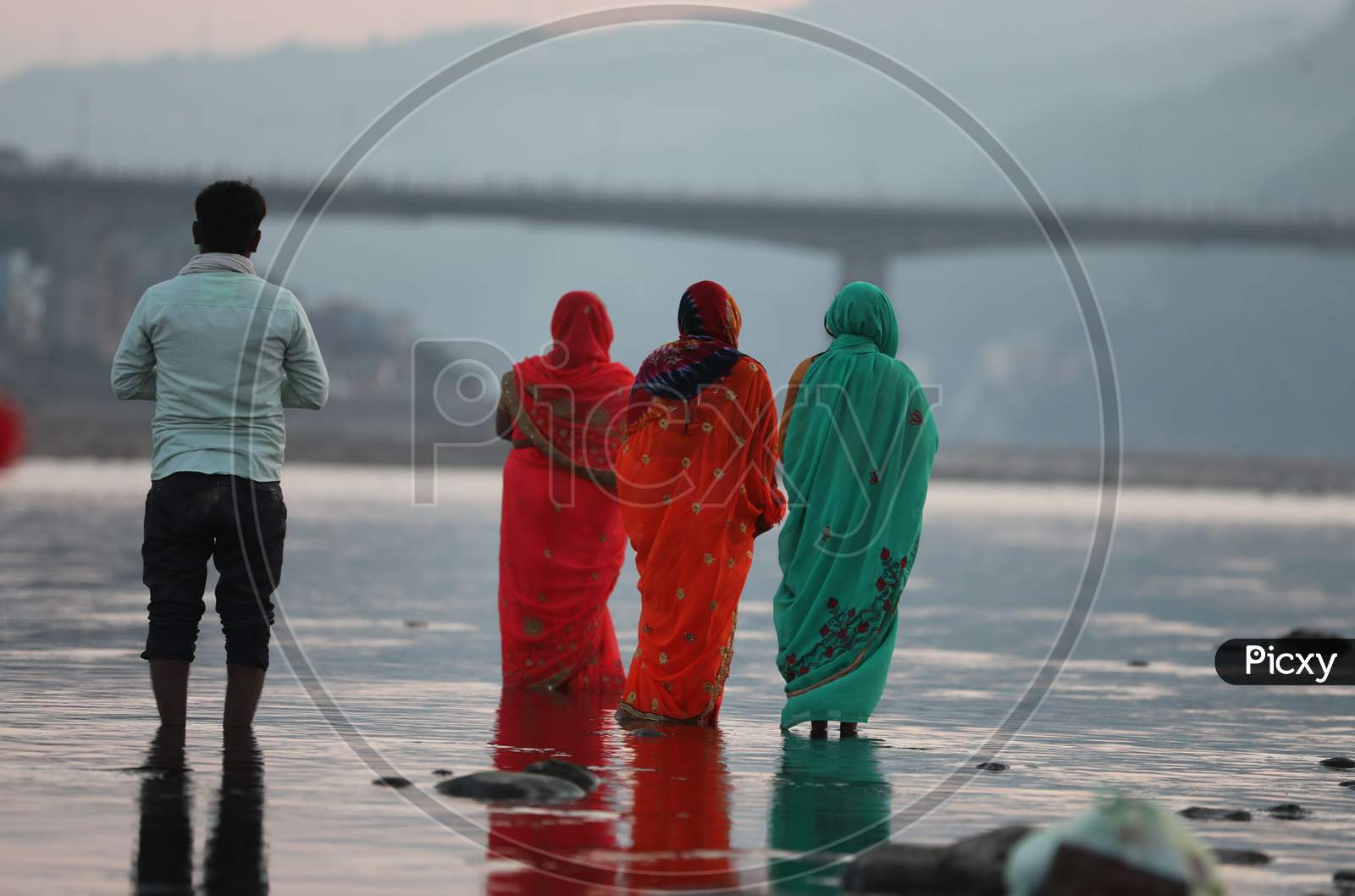 Devotees perform rituals during 'Chhath Puja' celebrations, on the banks of River Tawi in Jammu, Saturday, Nov. 21, 2020.