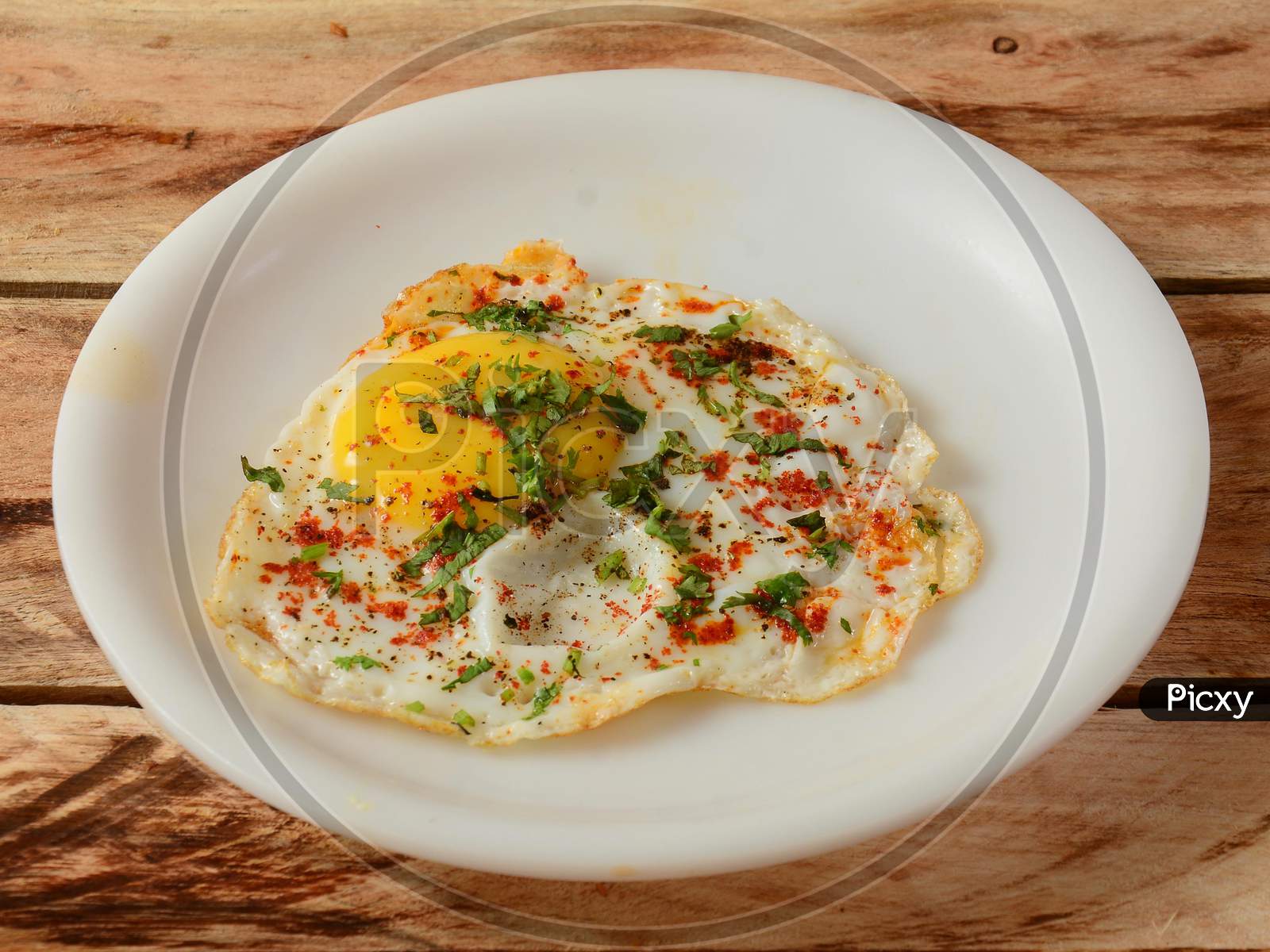 Indian Style Tasty And Healthy Egg Half Fried Omelet On A Wooden Rustic Background. Selective Focus