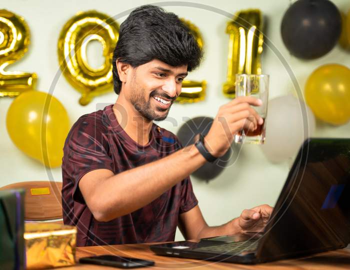 Young Man Partying During New Year Or Christmas Celebration Video Call On Laptop - Concept Of Distant Holyday Celebration Due To Coronavirus Or Covid-19 Pandemic.
