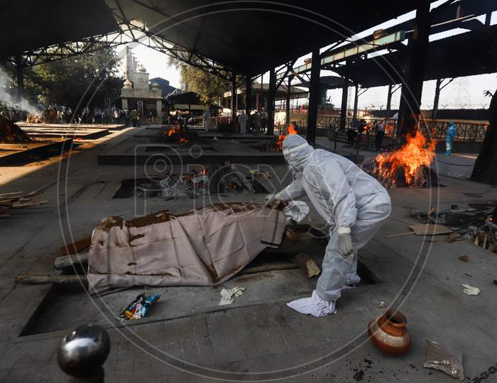 A relative performs final rituals for Covid-19 victim at Nigambodh Ghat crematorium, on November 21, 2020 in New Delhi, India. India records 46,232 fresh coronavirus cases, 564 COVID-19 deaths, and 49,715 one-day recoveries in the last 24 hours, shows government data.