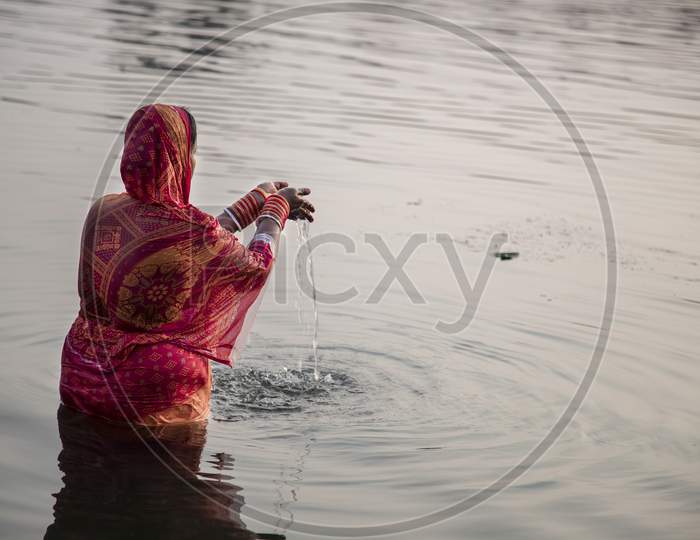 Woman devotee performing rituals on Chhath Puja celebration admist Covid-19 pandemic