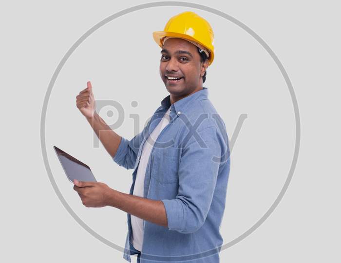 Construction Worker Holding Tablet In Hands Showing Back. Man Using Tablet. Architect Holding Tablet. Yellow Hard Helmet. Worker Isolated