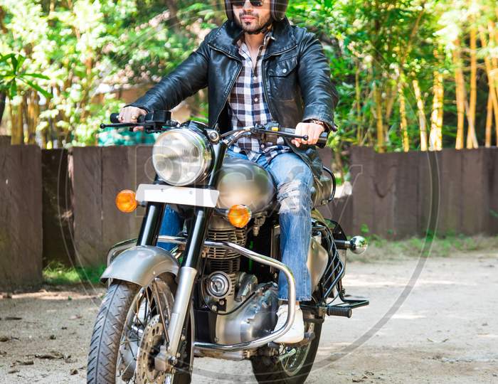 Handsome Serious Indian Asian Young Man Biker On Bike Outdoors At The Forest Field Looking Aside