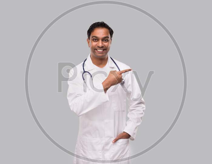 Doctor Pointing To Side And Watching Front. Isolated