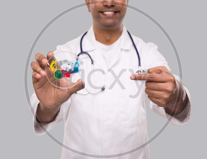 Doctor Pointing At Petri Dish Smilling Isolated Close Up. Medicine, Science Concept