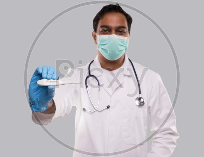 Doctor Showing Thermometer Wearing Medical Mask And Gloves Isolated. Indian Man Doctor With Thermometer In Hands. Healthy Life, Doctor, Virus Concept