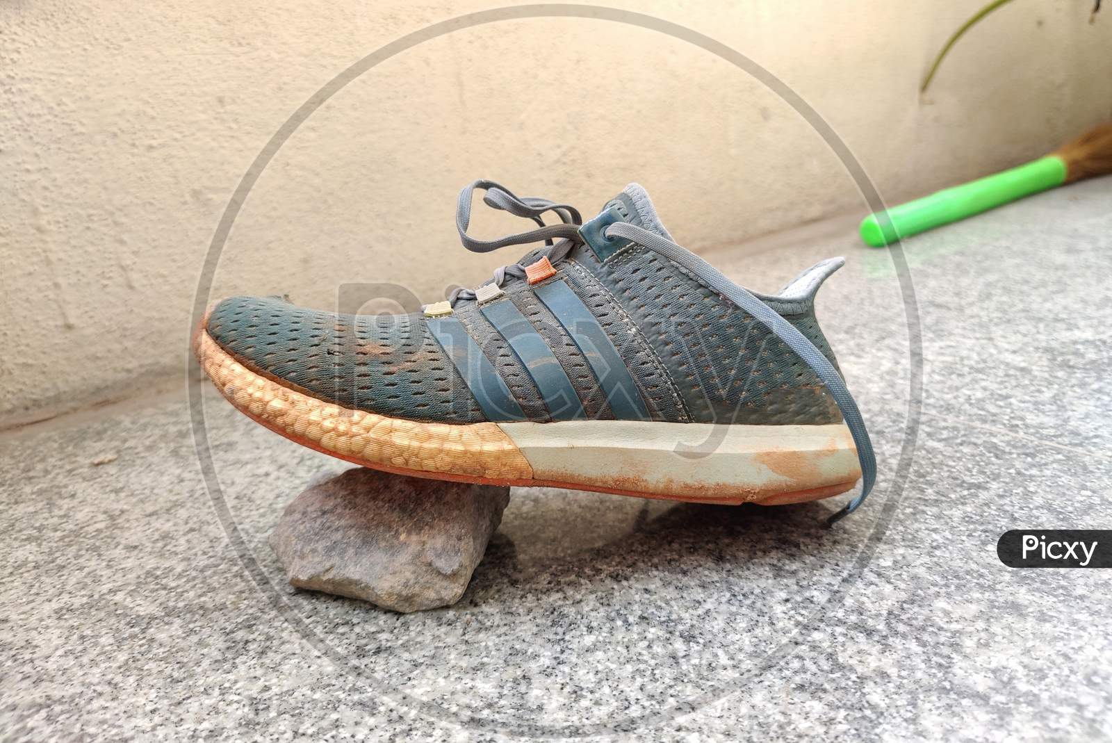 Side View Of Dusty, Torn And Old Green Color Sneakers Shoe