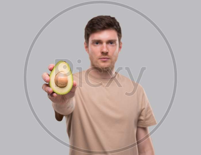 Man Showing Avocado Serious Face Isolated. Avocado Cut In Half. Healthy Food, No Avocado, Stop Avocado Concept