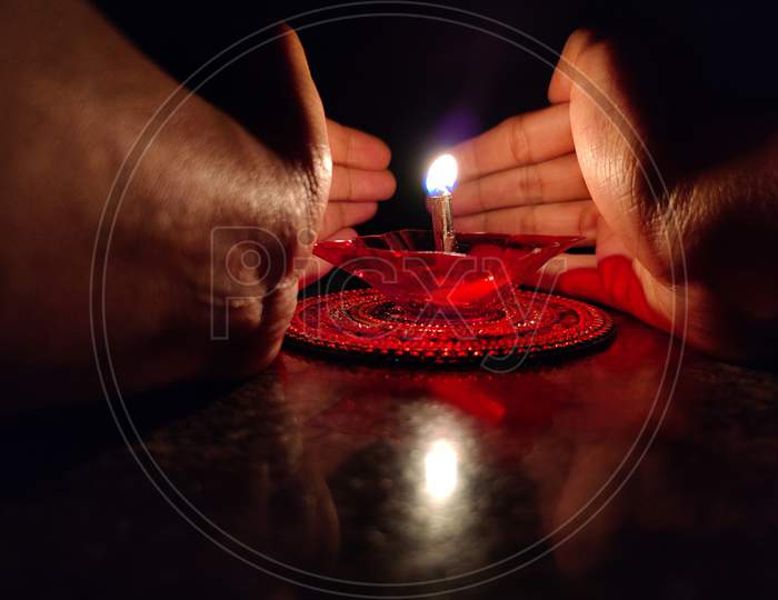 Hands Of Indian Women Covering Oil Lamp On The Occasion Of Diwali Festival