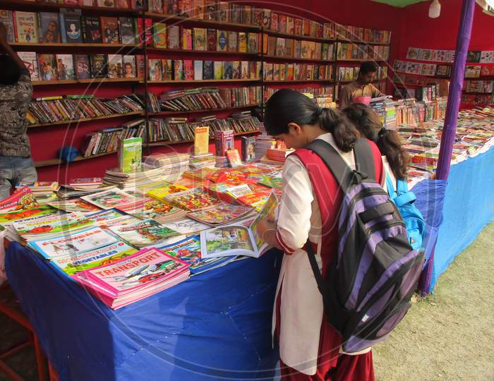 West Bengal , India March 02, 2020 : Indian Book Fair, There Are Many Bengali Books In The Fair Shop And A College Student Reading A Book .
