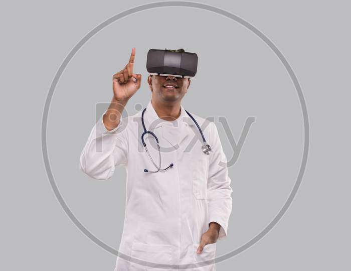 Doctor Wearing Vr Glasses Tapping Isolated. Indian Man Doctor Pointing In Virtual Reality