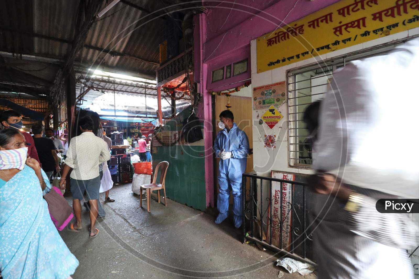 A health worker in personal protective equipment (PPE) waits to collect swab sample from people during a rapid antigen testing campaign for the coronavirus disease (COVID-19), at a vegetable market in Mumbai, India, November 21, 2020.