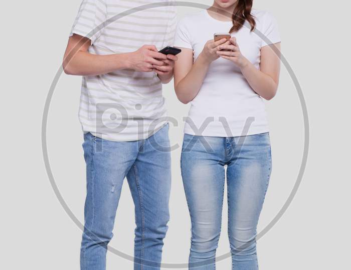 Couple Chatting On Phone. Couple Using Phones Standing Isolated. Couple Shopping Online. Man Watching In Girls Phone.