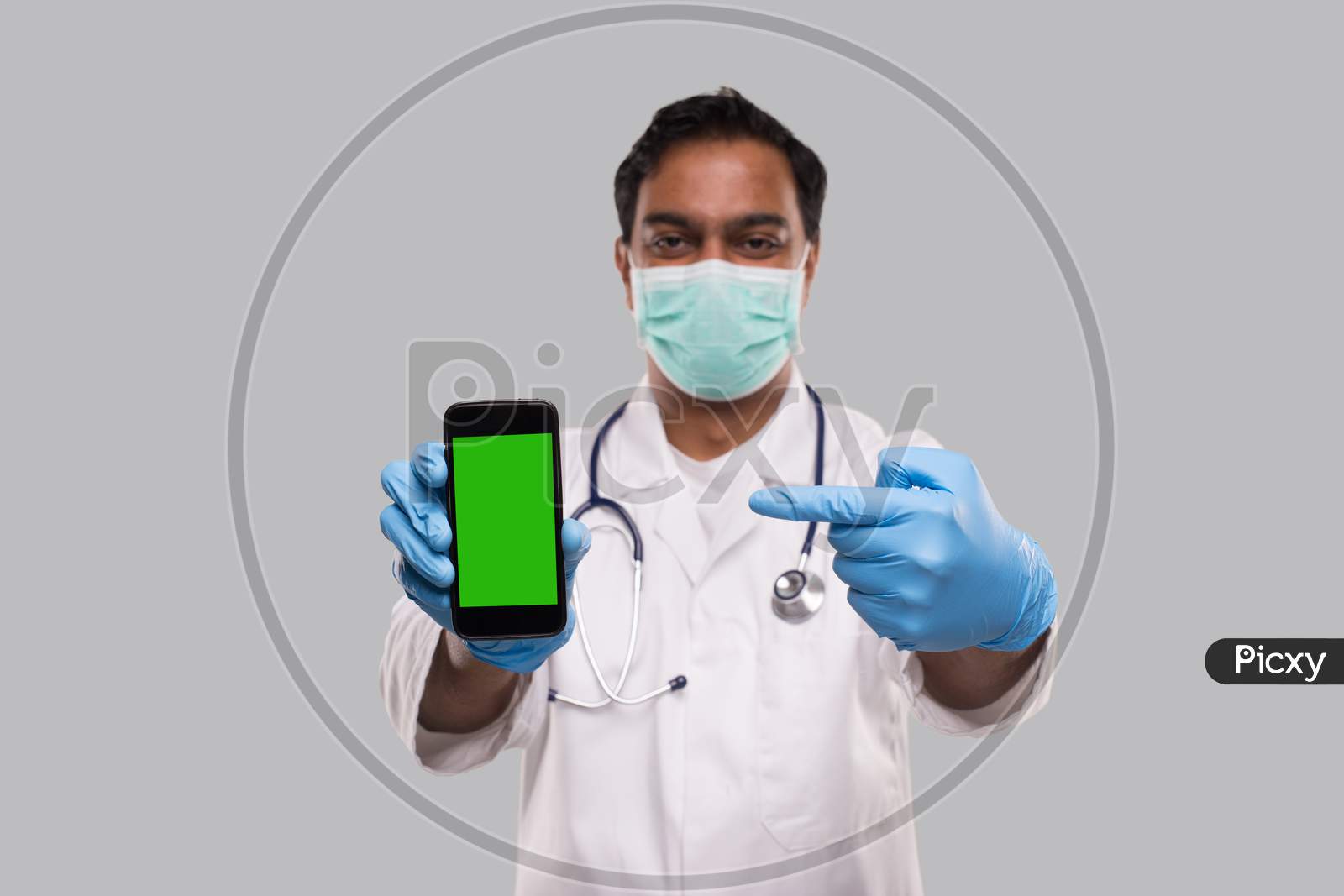Doctor Pointing At Phone Wearing Medical Mask And Gloves. Indian Man Doctor Technology Medicine At Home. Phone Green Screen Isolated