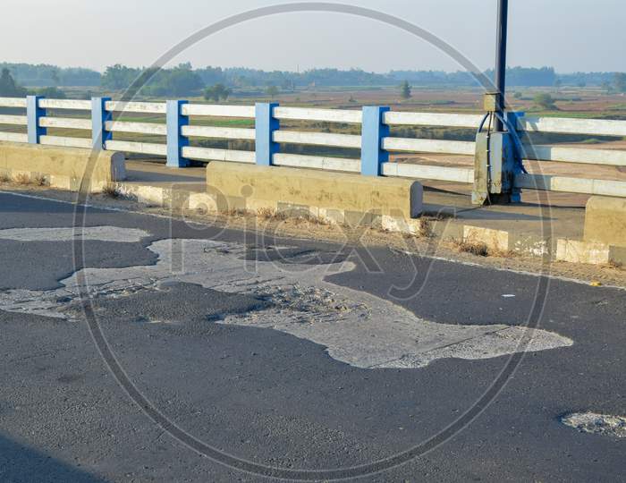 Damaged asphalt road in rural Bengal