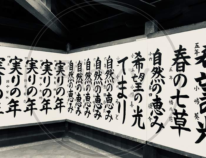 Art of calligraphy with Japanese characters on wall of temple in Japan