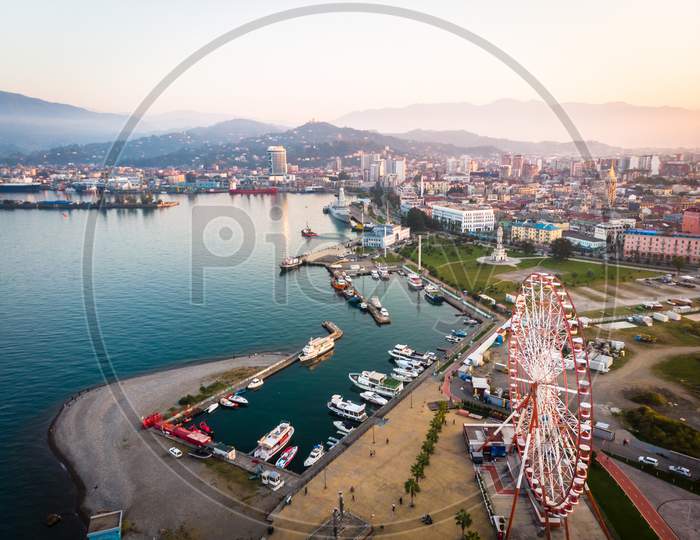 Batumi Port With Many Ships And Boats Standing And Cauacasus Mountains In The Background. Batumi Tourism And Black Sea Coast.