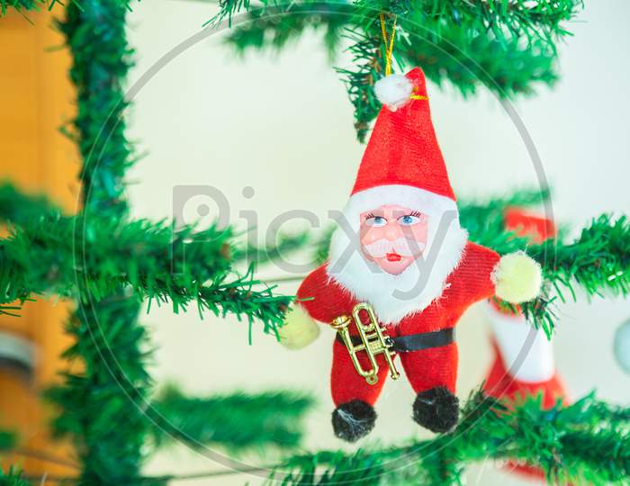Cute Santa Claus Toy Hanging On Tree, Christmas Background, Decoration, Celebration, Greetings, Copy Space.